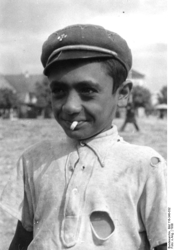 Boy with hat, torn shirt and cigarette butt in the mouth